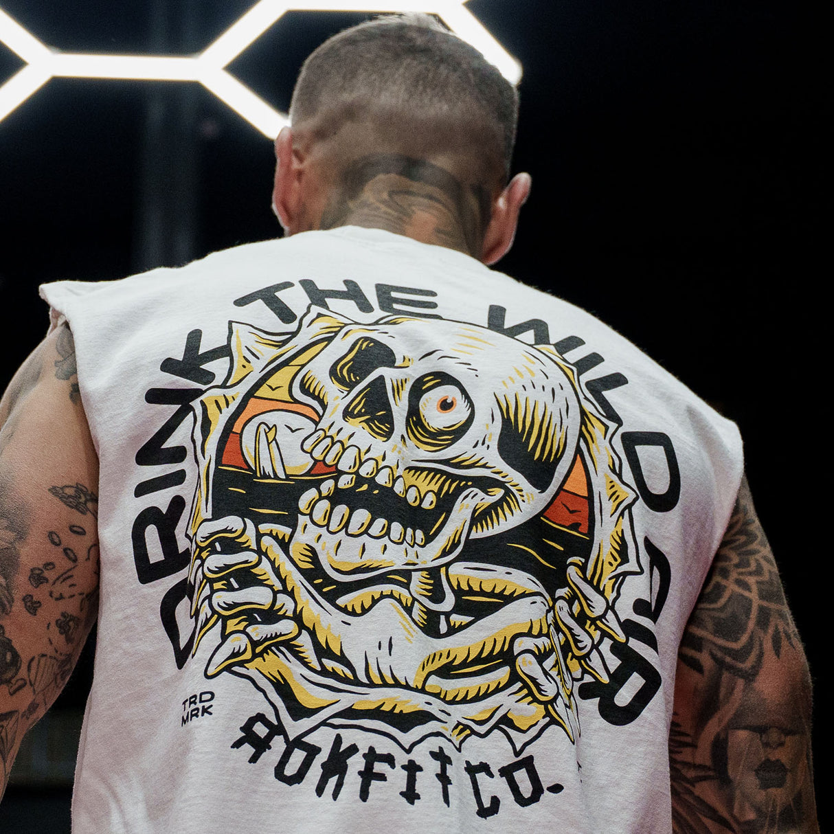 Male model in gym wearing a sleeveless street tee with 'Drink The Wild Air' graphic