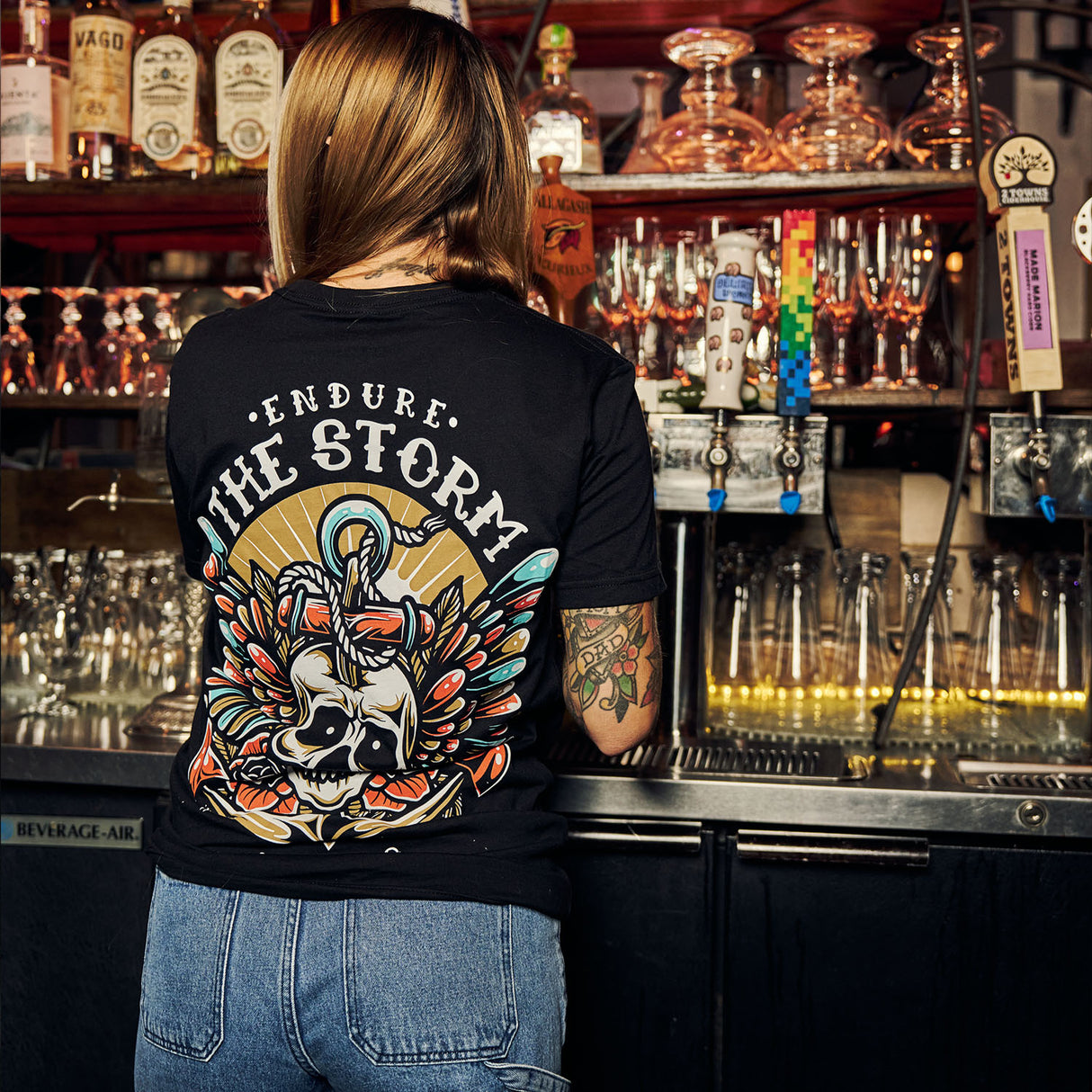 Female model in bar wearing black Active Tee with 'Endure The Storm' graphic