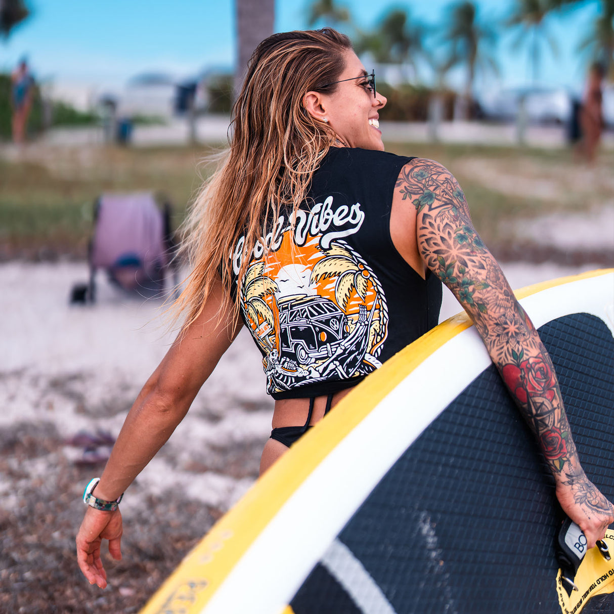 Female model outdoors wearing black sleeveless Active Tee with 'Good Vibes' graphic