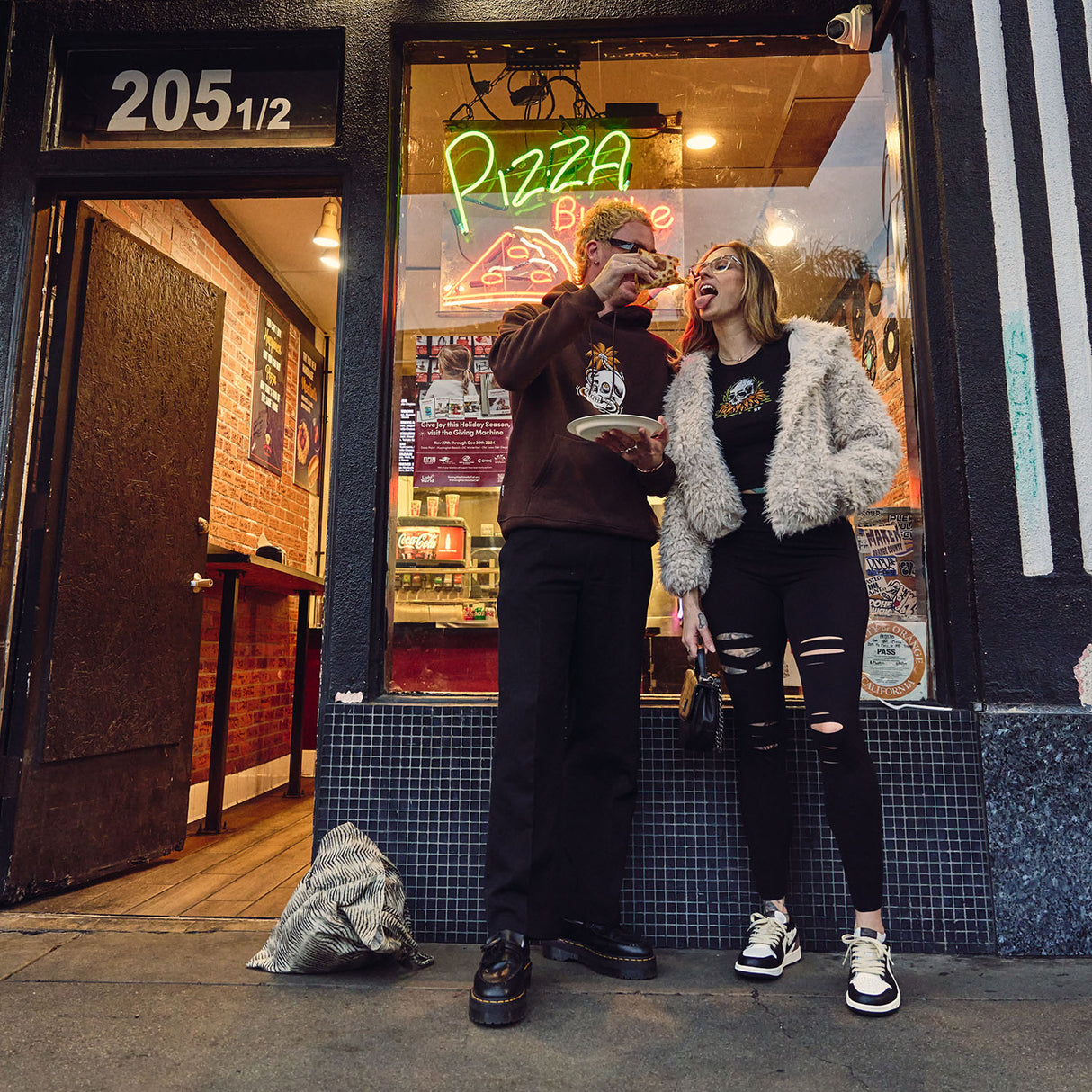 Female model outdoors wearing Cutline Leggings eating pizza